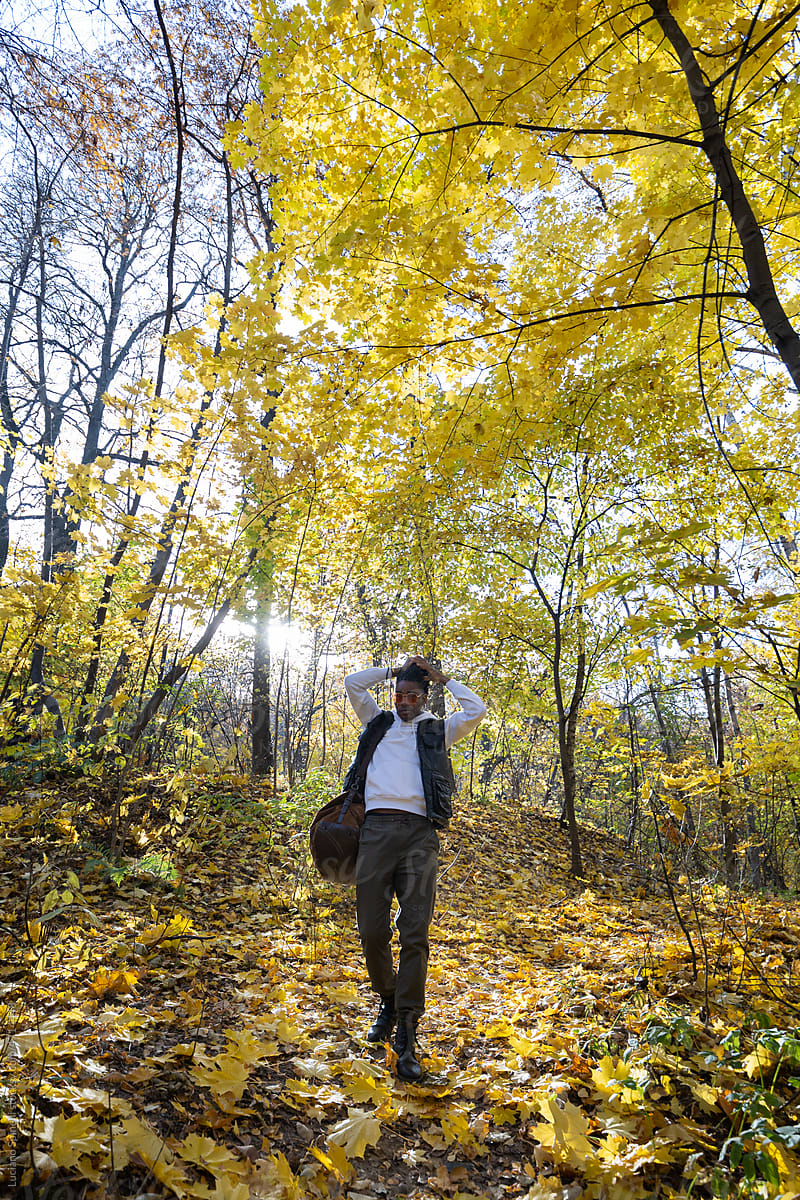 Man walking in the forest during an autumn afternoon