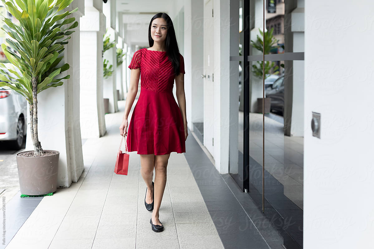 A Full Length Image Of A Asian Woman In Red Walking Along An Arcade In 5521