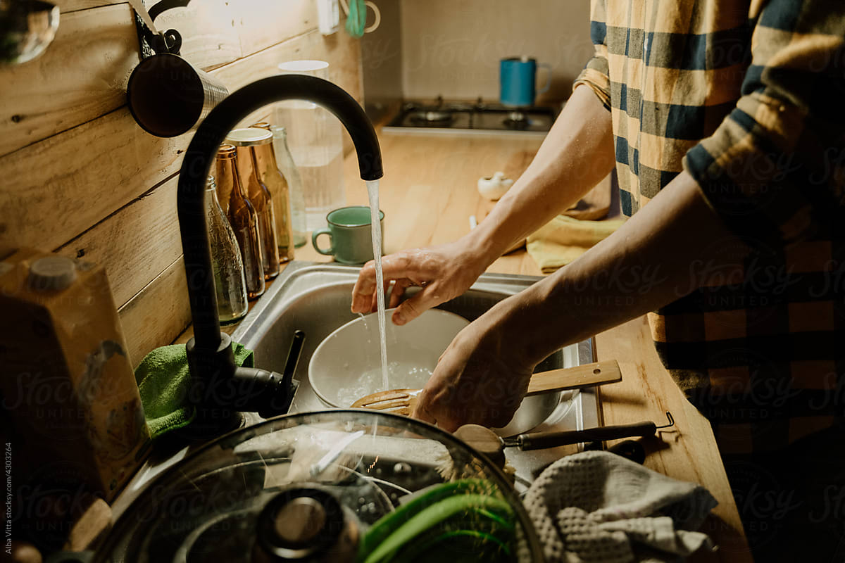 Man washing dishes at home kitchen