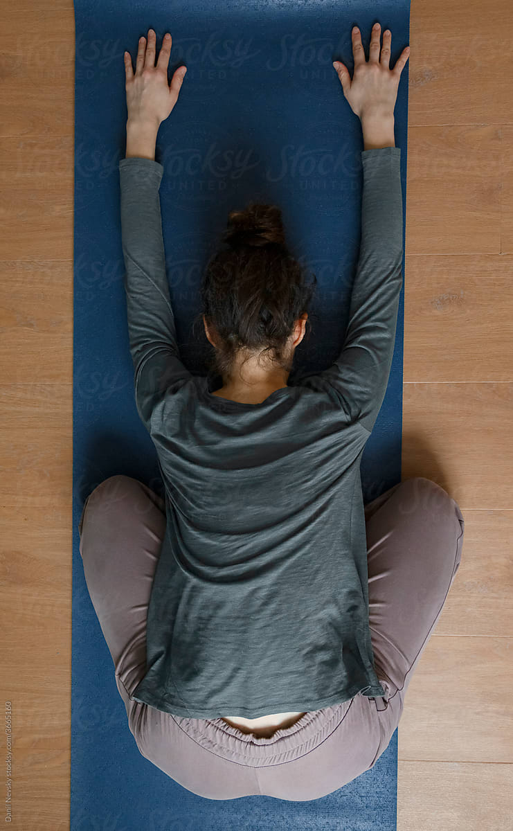 Woman stretching body in forward bend yoga position