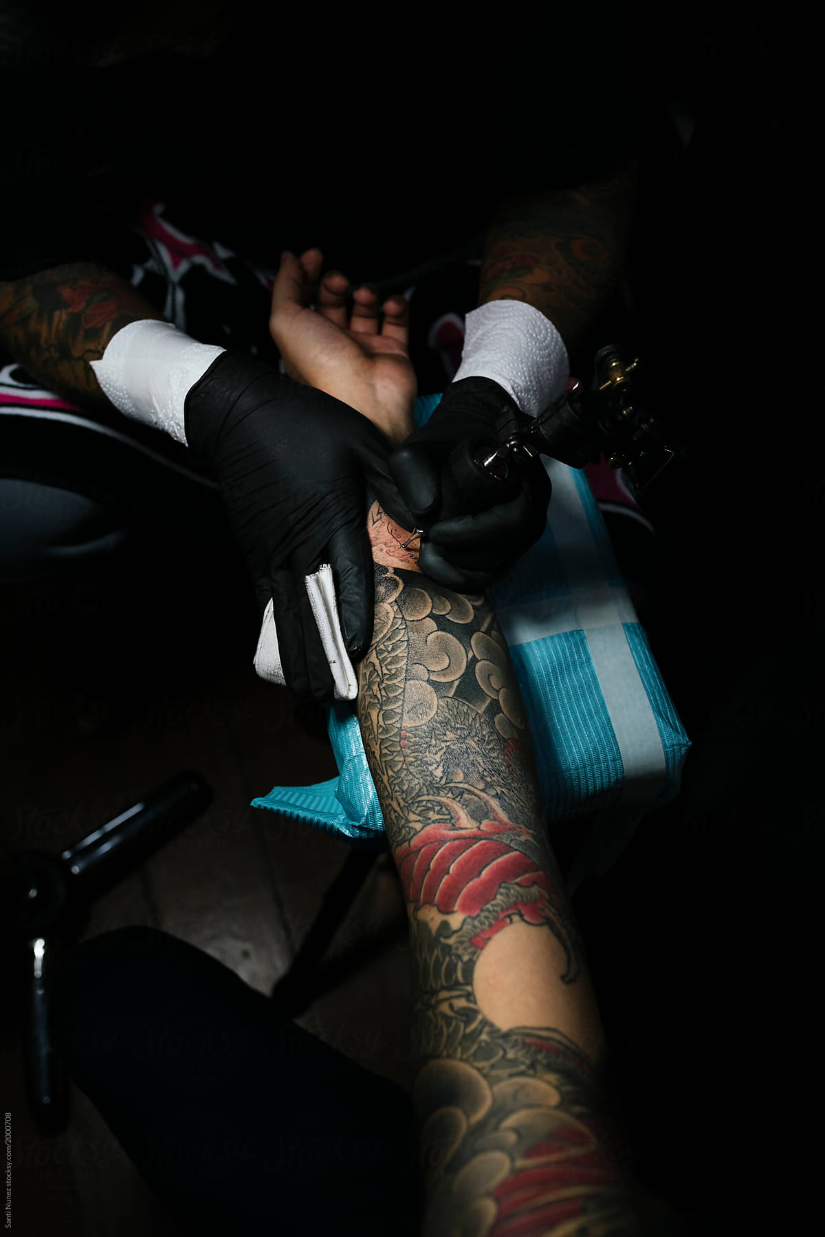 Closeup of asian tattooer makes a tattoo.