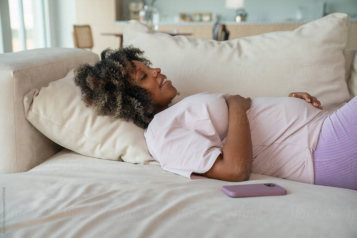 Pregnant woman lay on couch at home