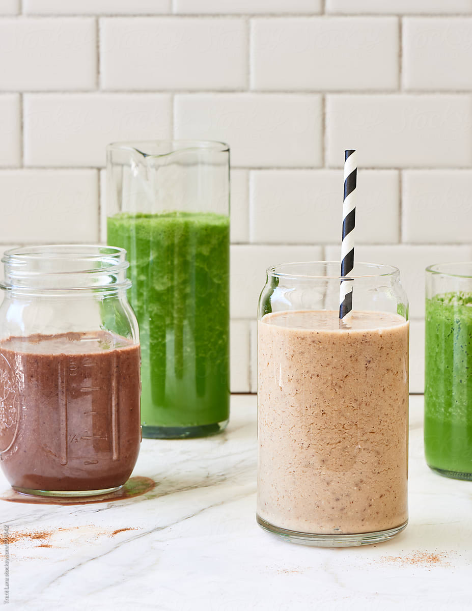Delicious detox smoothies on table against of tiled wall
