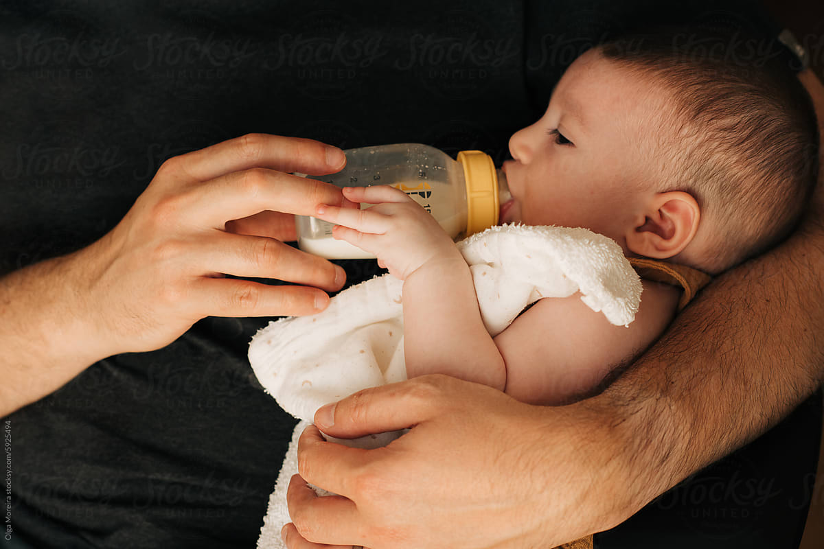 Anonymous father bottle feeding a baby