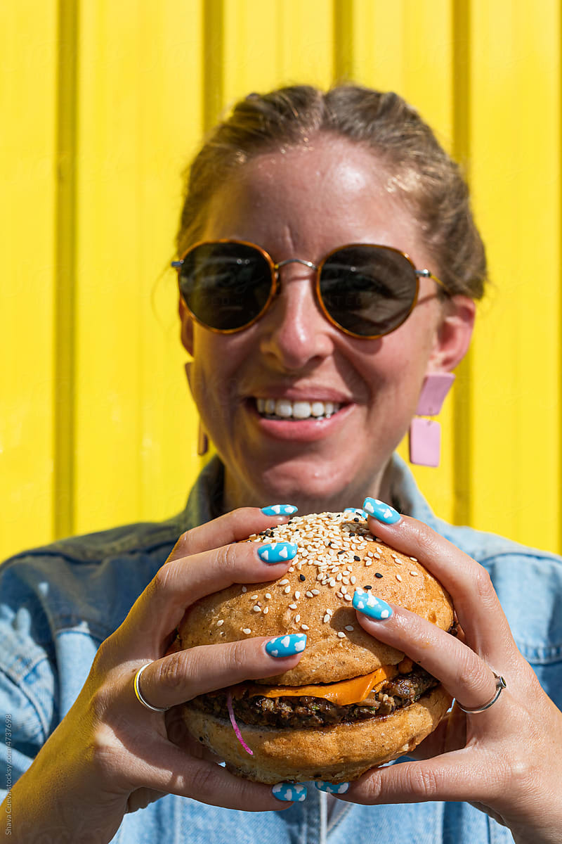 A woman holding a big hamburger