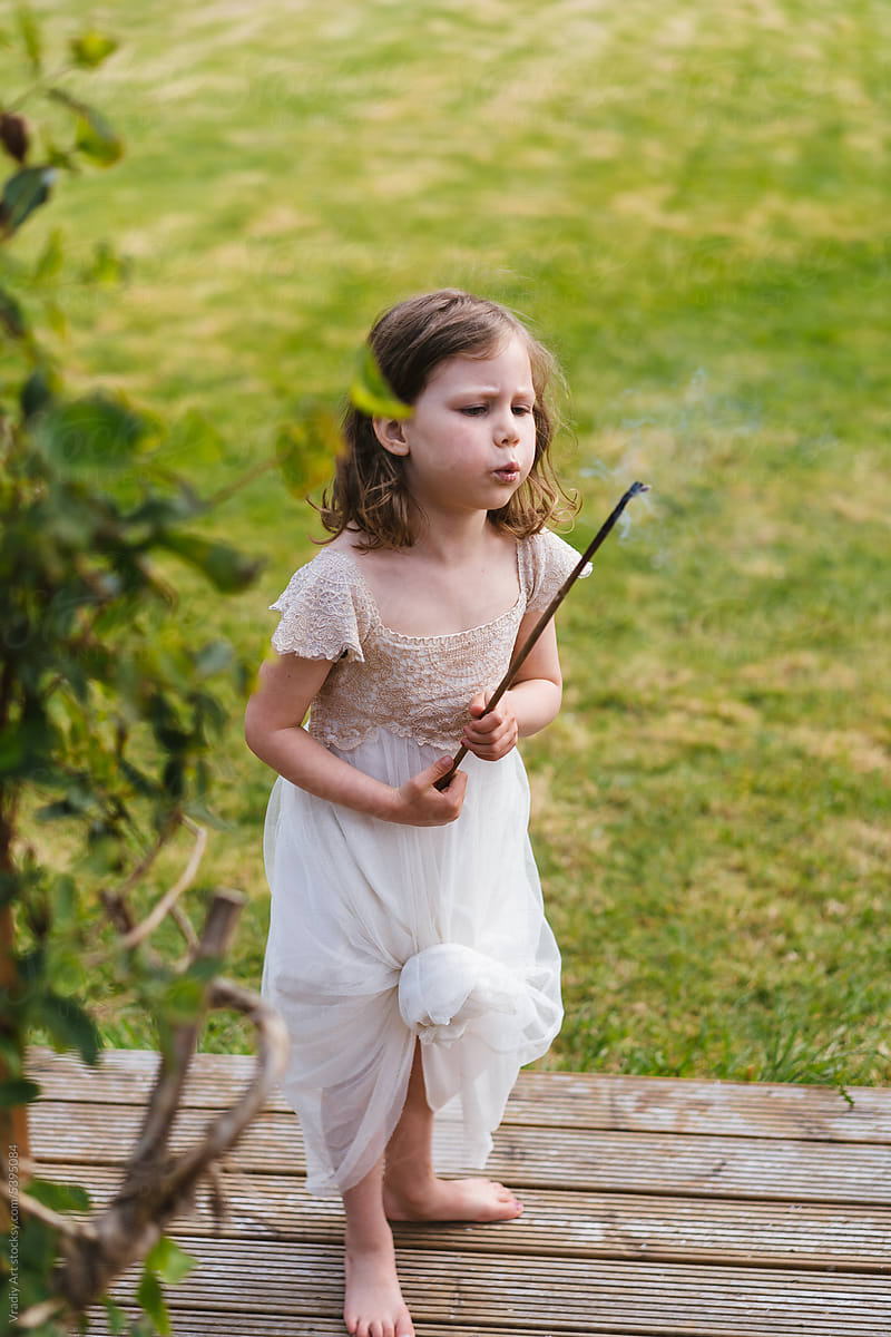 Little girl with stick during bbq party
