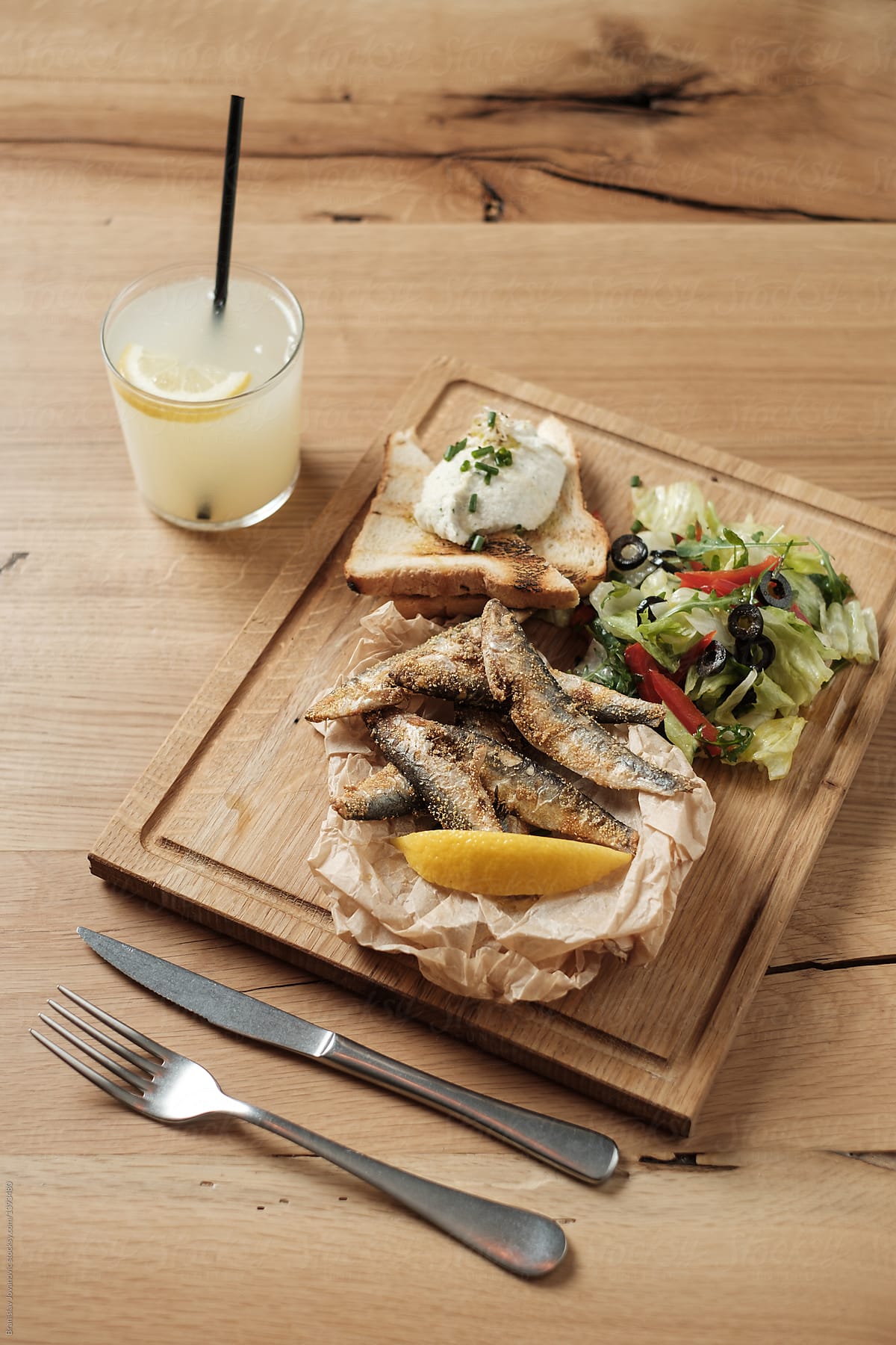 Fried Fish And Salad On The Wooden Board