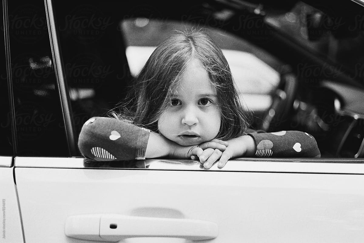 Cute young girl looking out the window of a car