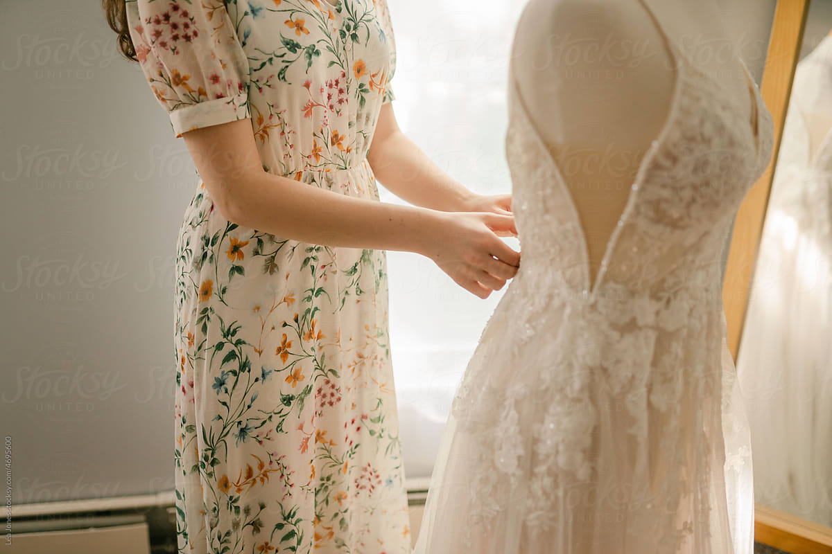 seamstress adjusting a wedding dress
