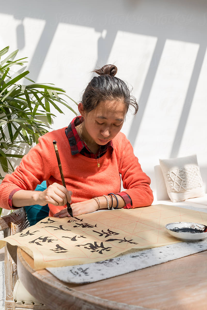 Woman painting chinese symbols