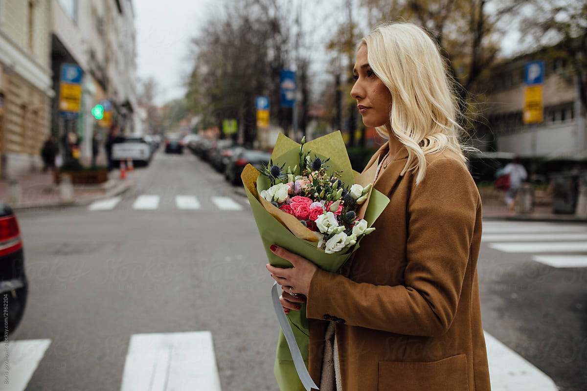 A Young Blonde Woman With A Flower Bouquet