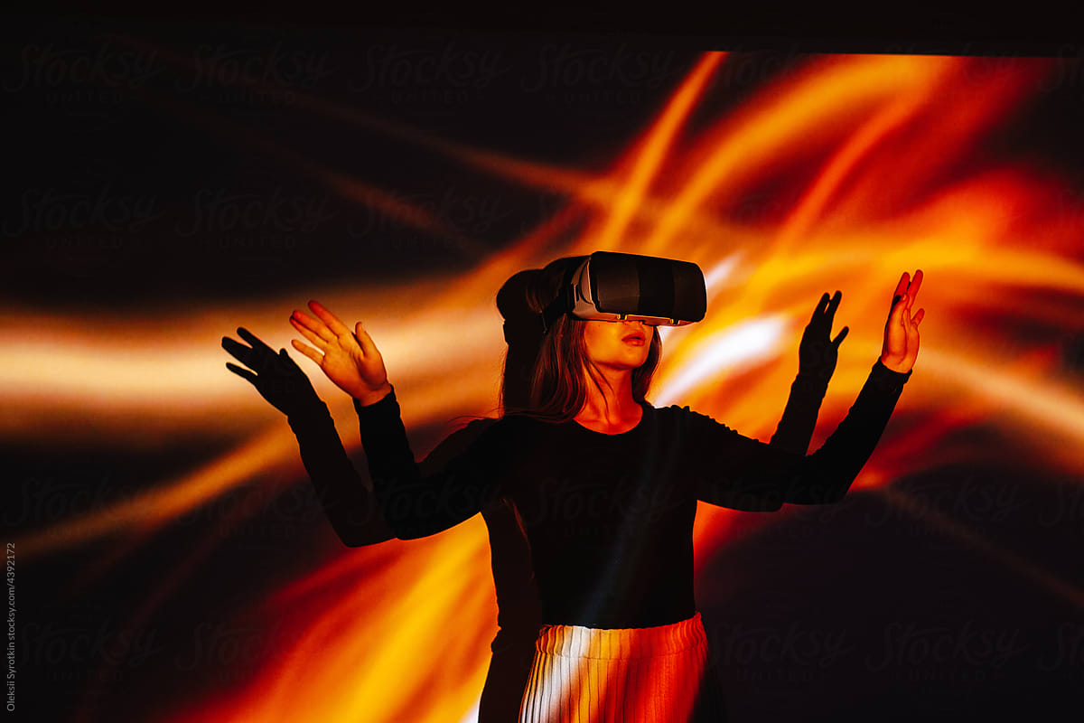 Girl in VR headset standing near glowing background