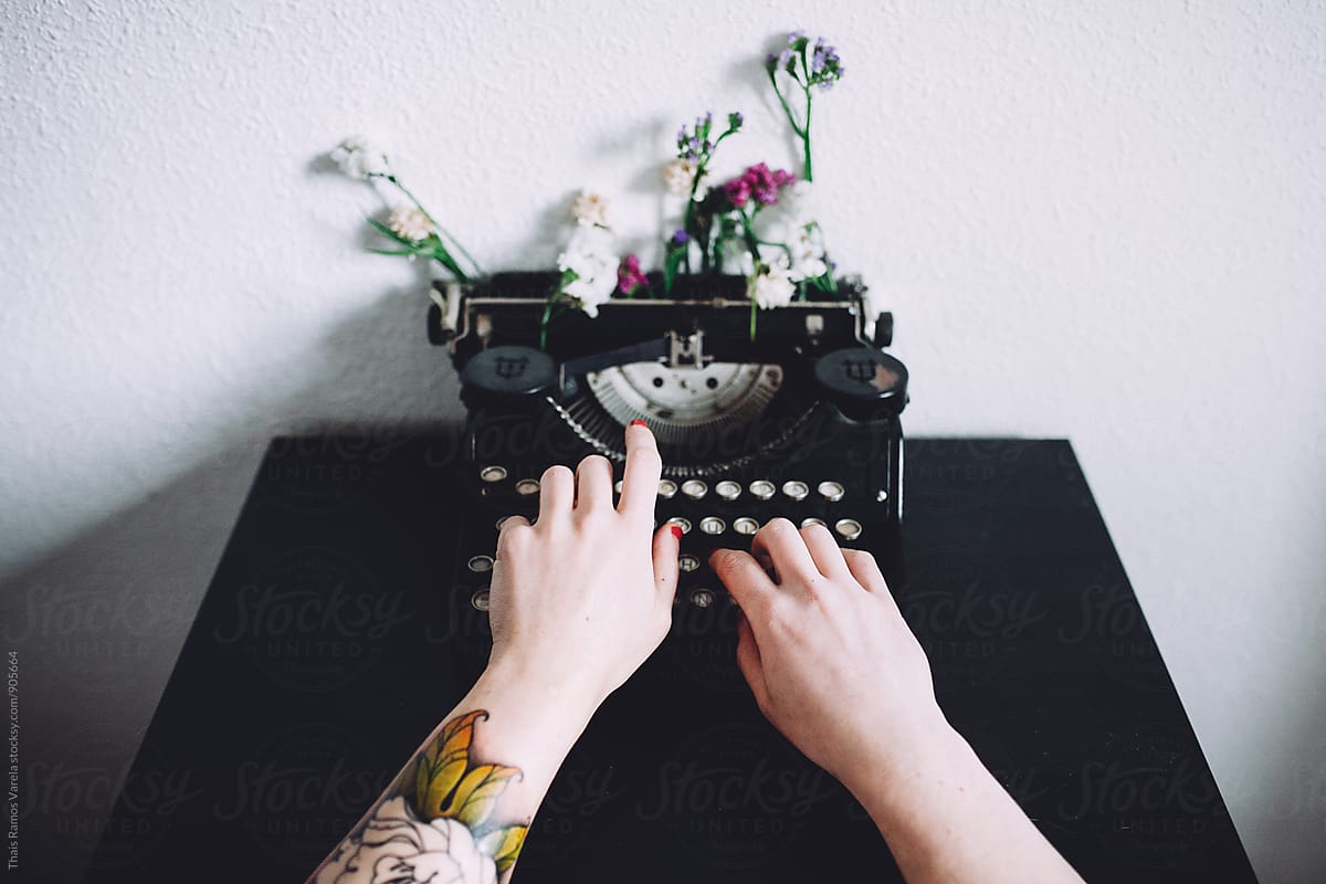 woman typing with a vintage typewriter
