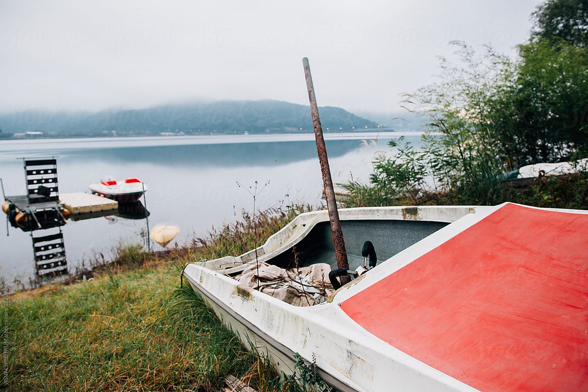 Broken Boat on Lake Shore on Foggy Morning