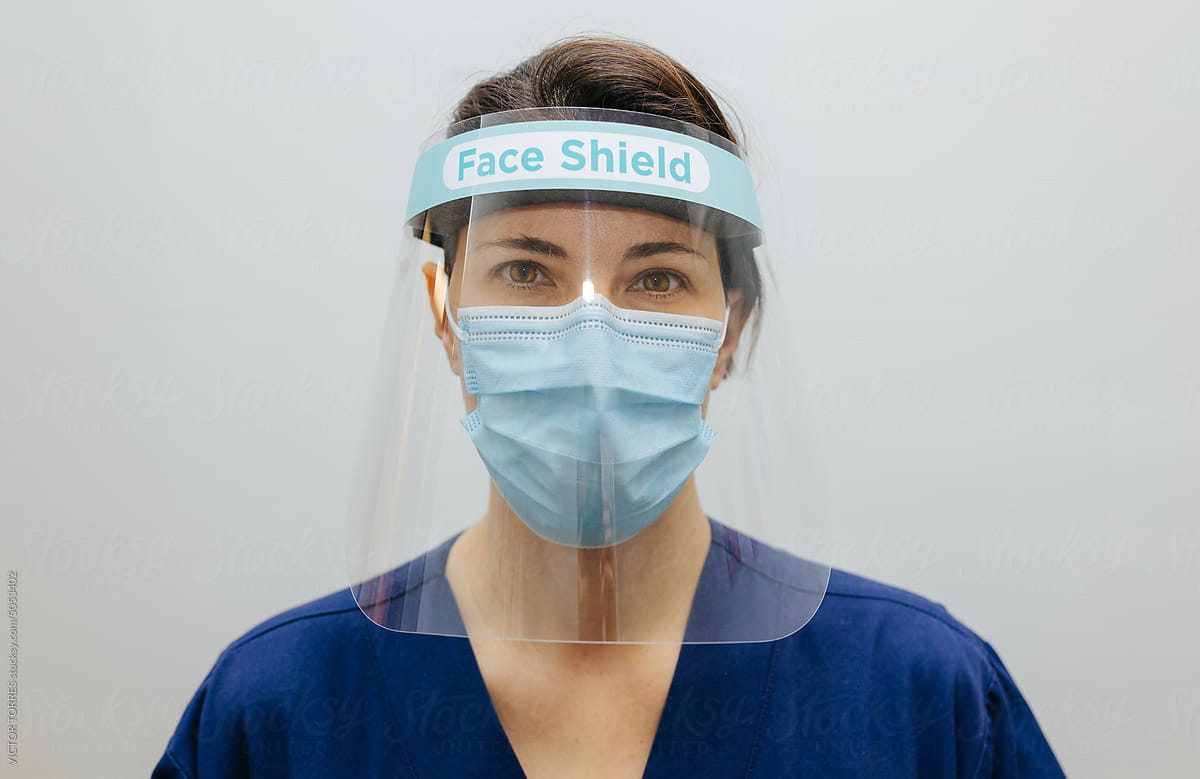 Scientist in uniform and face shield mask in IVF laboratory