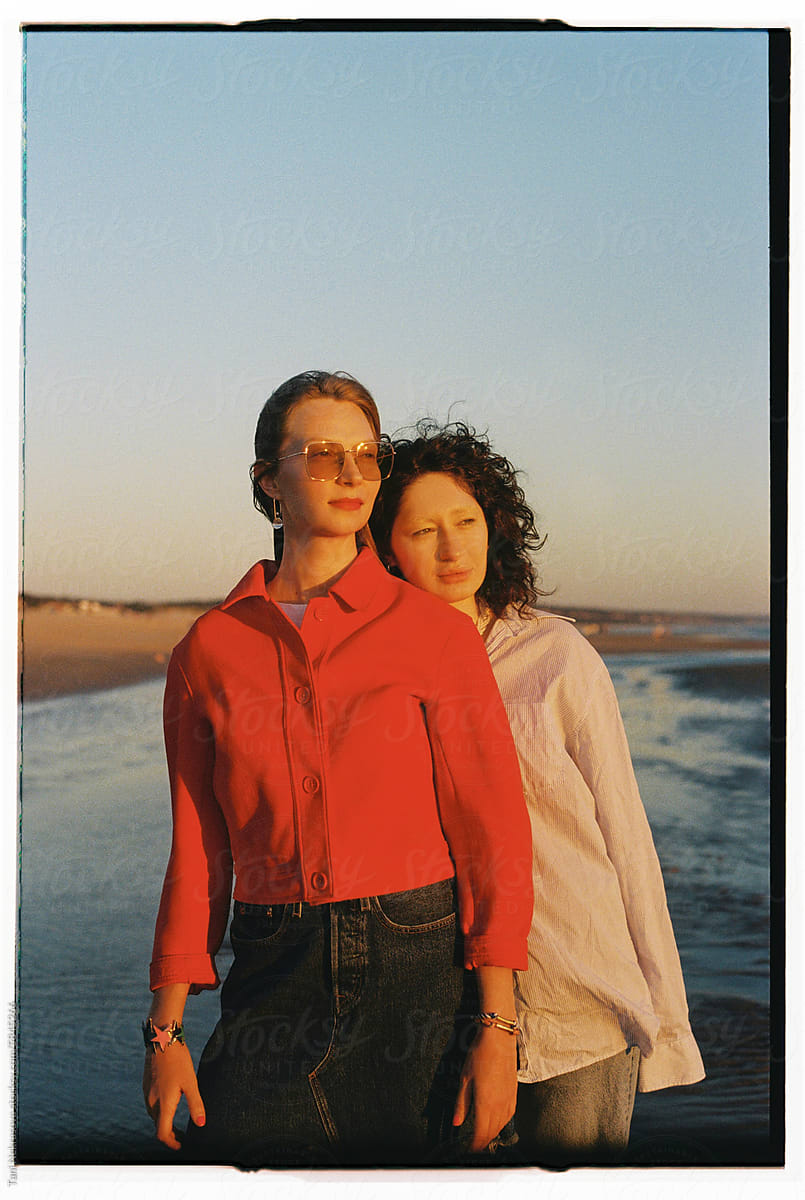 Film portrait of two young females standing by the ocean