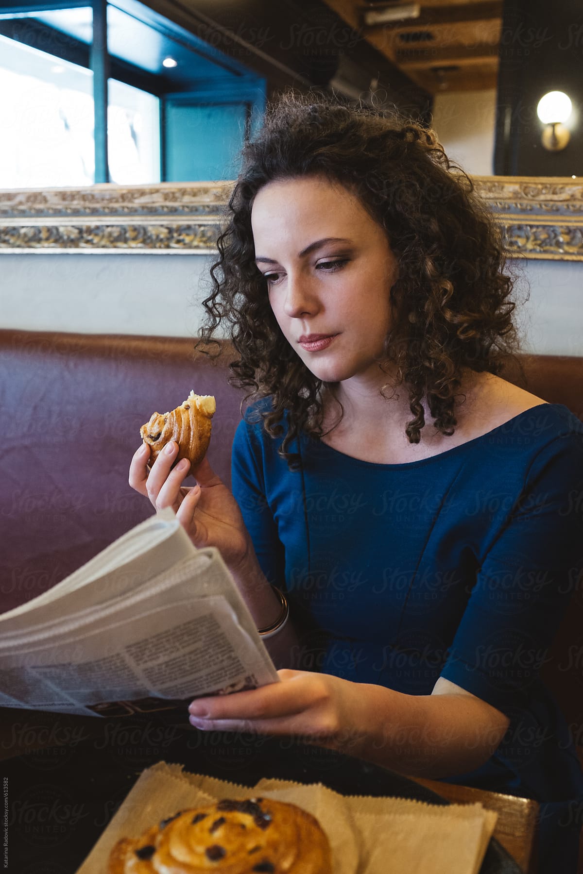 Brunette Woman Having Breakfast While Reading Newspapers By Stocksy Contributor Katarina