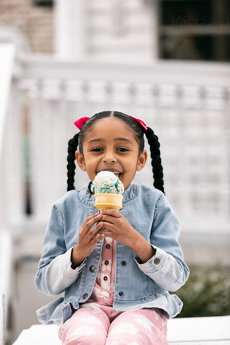 Young Girl Looks At Camera While Eating An Ice Cream Cone