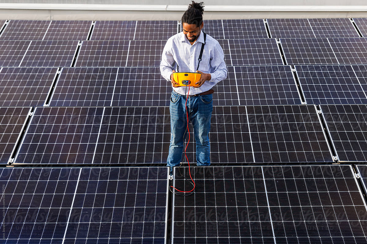 Engineer examining solar panels at rooftop