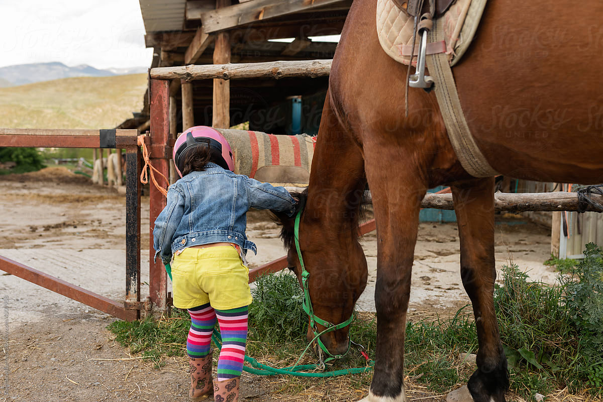 Girl caressing an horse at stable