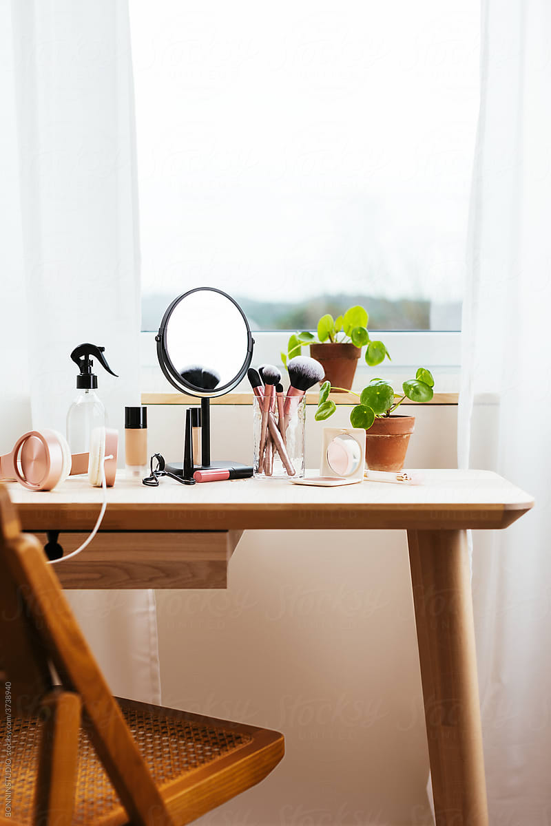 Table with makeup supplies near window
