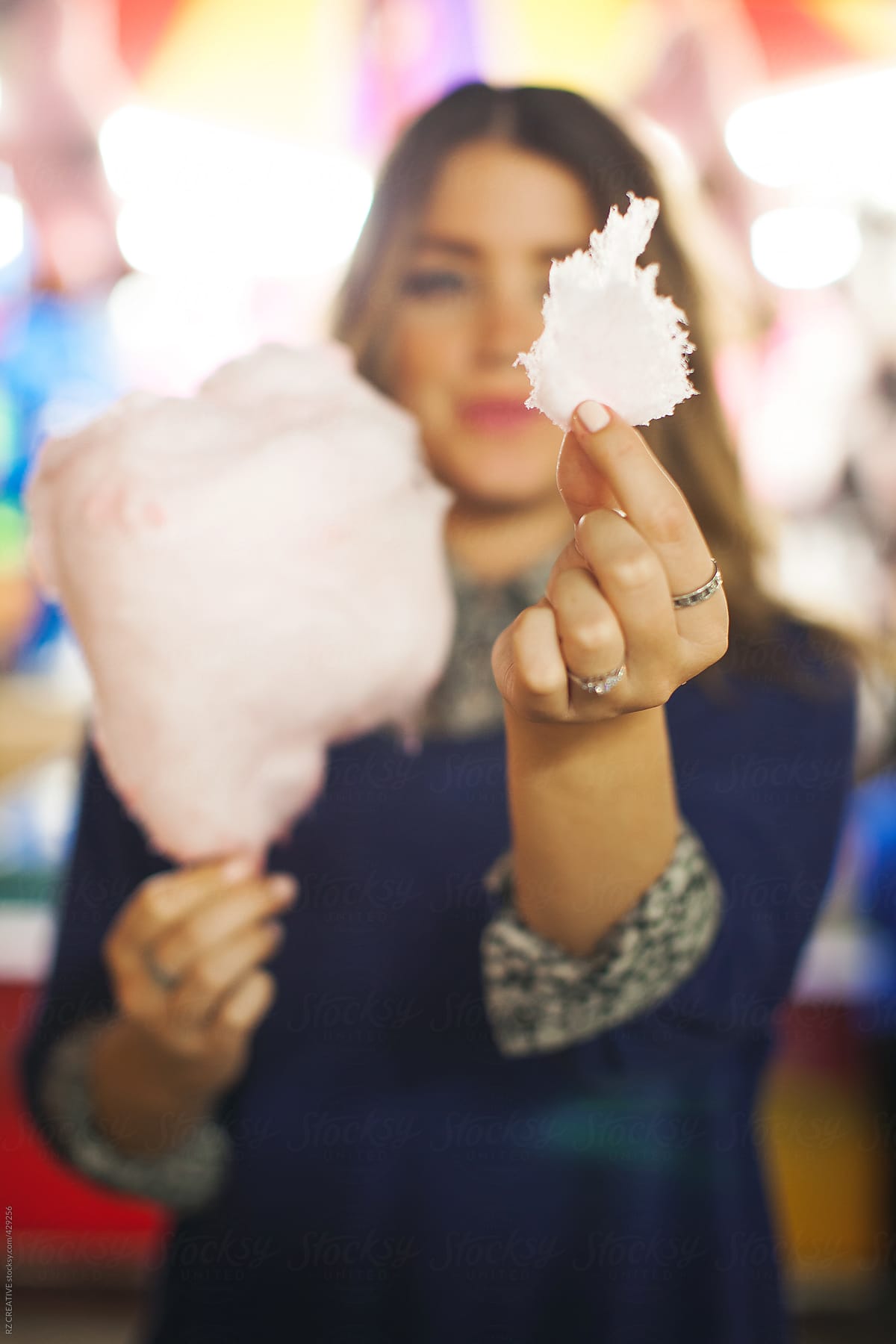 Pretty, stylish girl at a carnival with cotton candy.