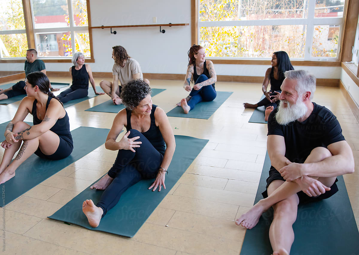 People chatting together during group yoga class.