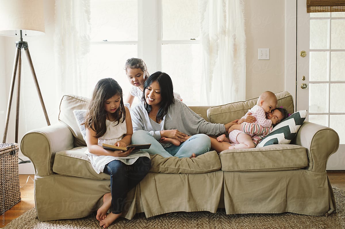 Mom and four daughters on couch reading for homeschool