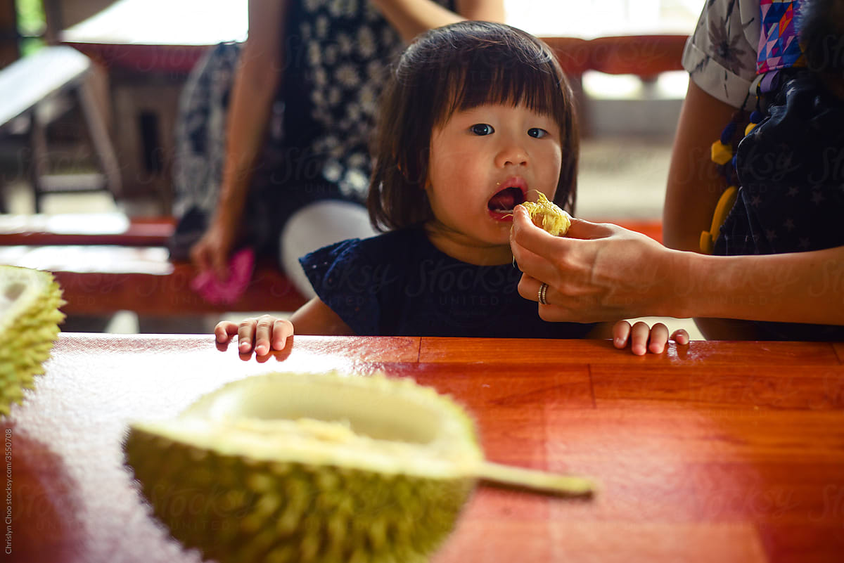 Asian child eating durian