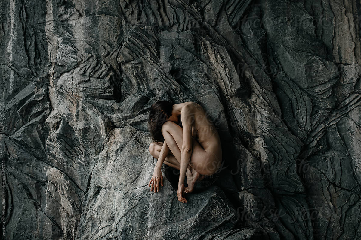 Anonymous Naked skinny woman sitting on a rock