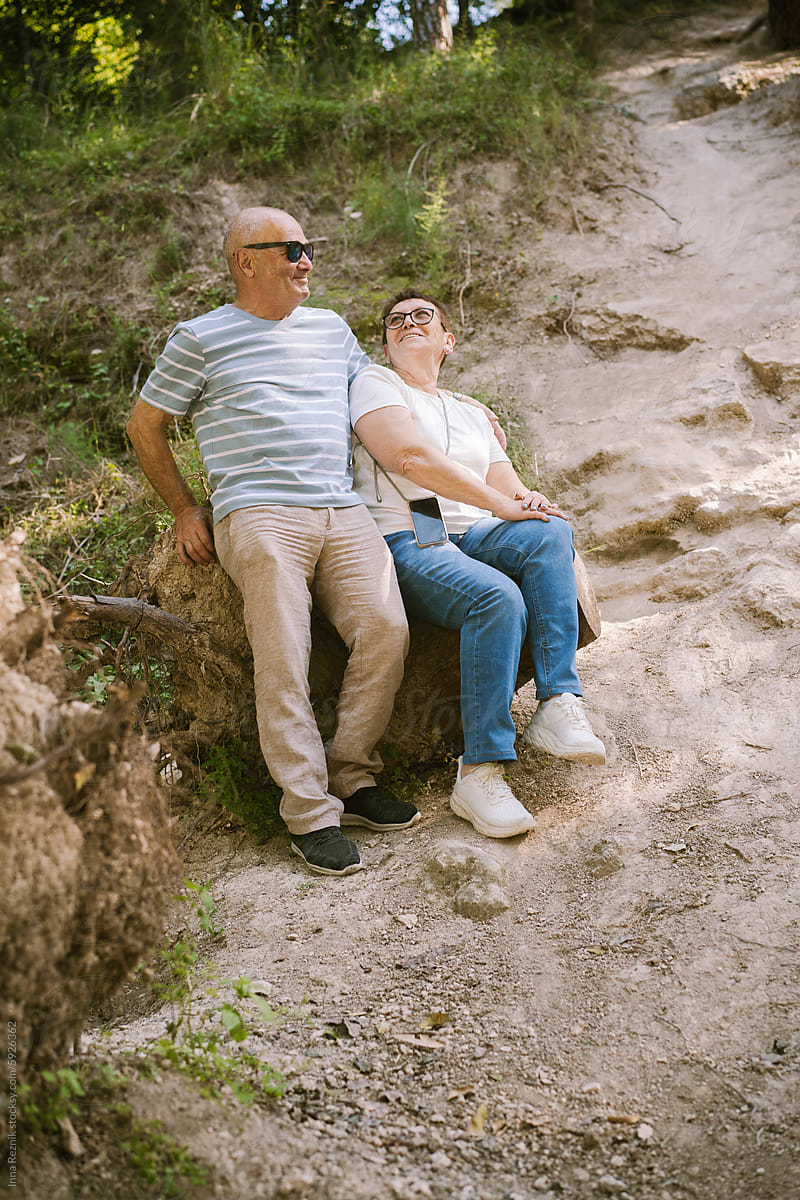 Contented Senior Couple Resting on Forest Trail.
