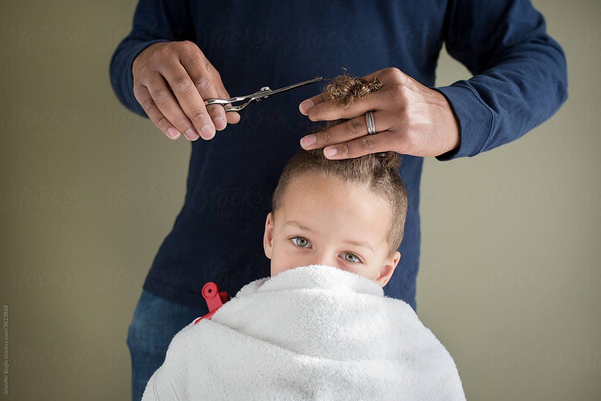 Boy with towel wrapped over face gets home hairut
