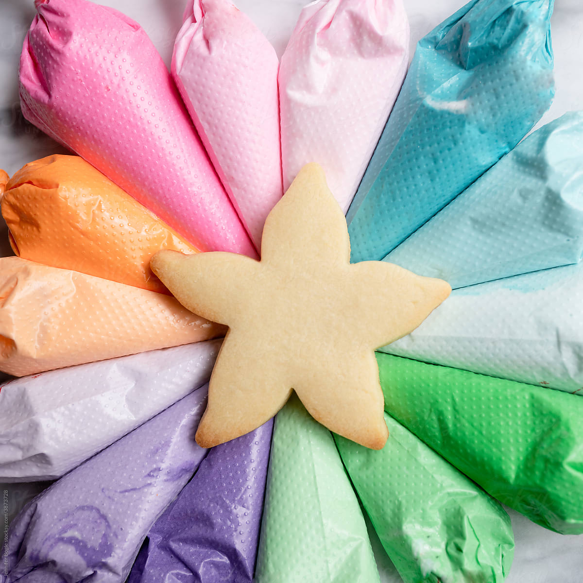 Starfish cookie surrounded by array of rainbow frosting