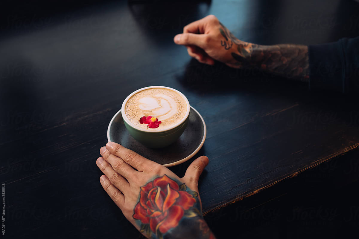 Man with tattoos having a coffee