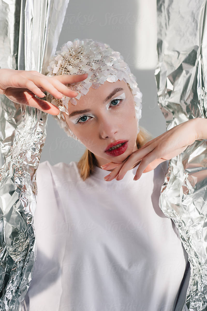 Stylish female with makeup against silver foil