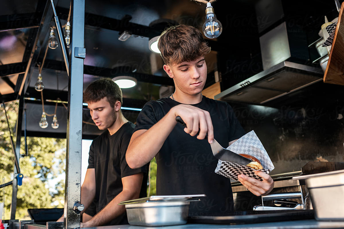 Teen chef cooking cheeseburgers in a food truck
