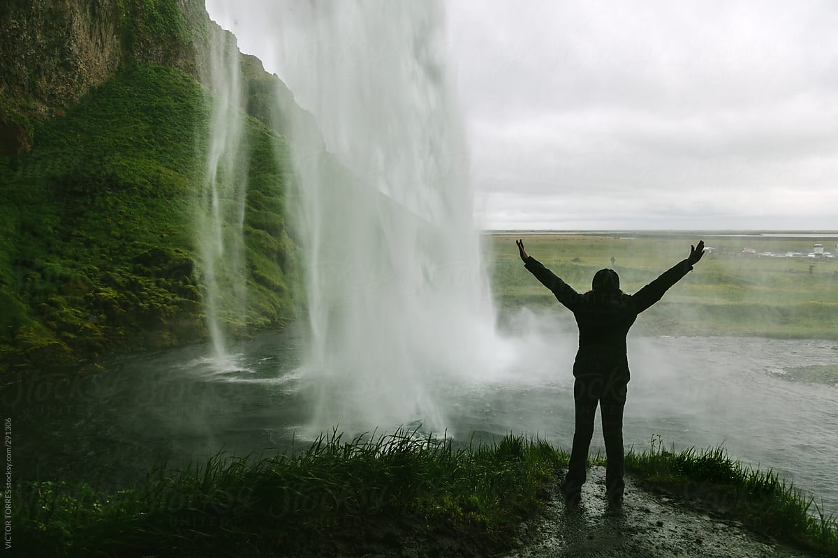Person inside the Seljalandsfoss Waterfall, Iceland