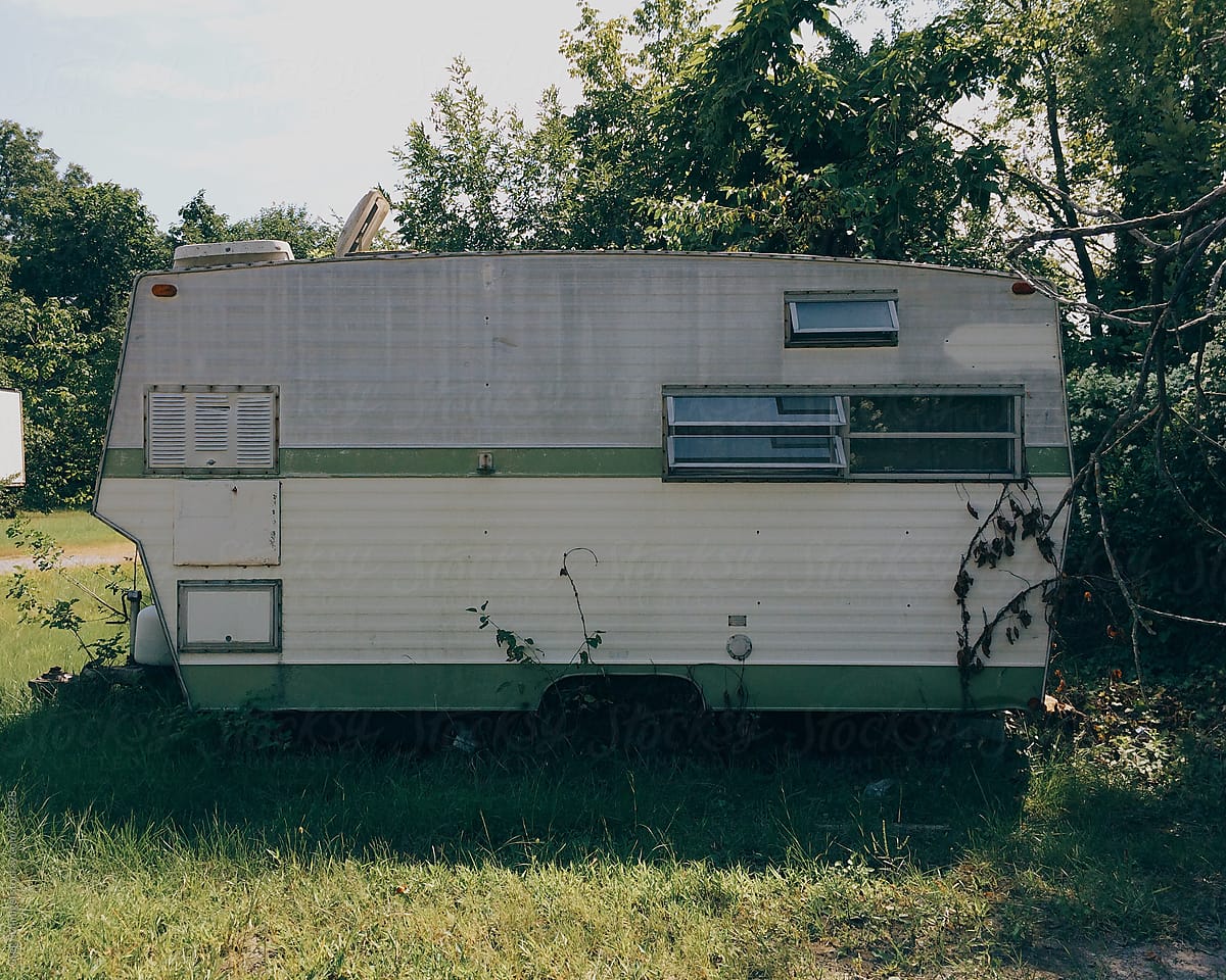 An abandoned mobile home travel trailer camper home in a forest, trailer park