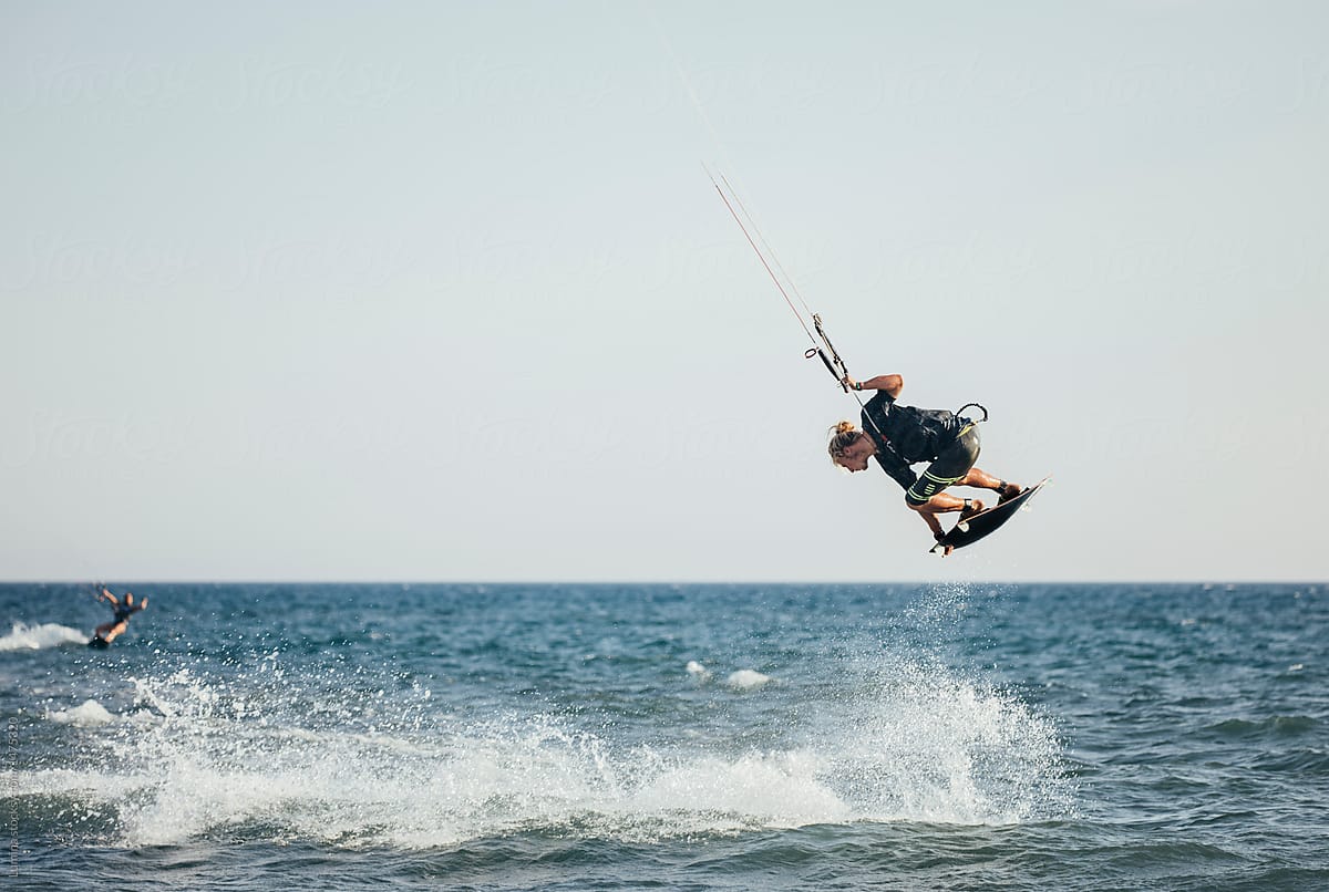 A Man Professional Kitesurfer Jumping with Board