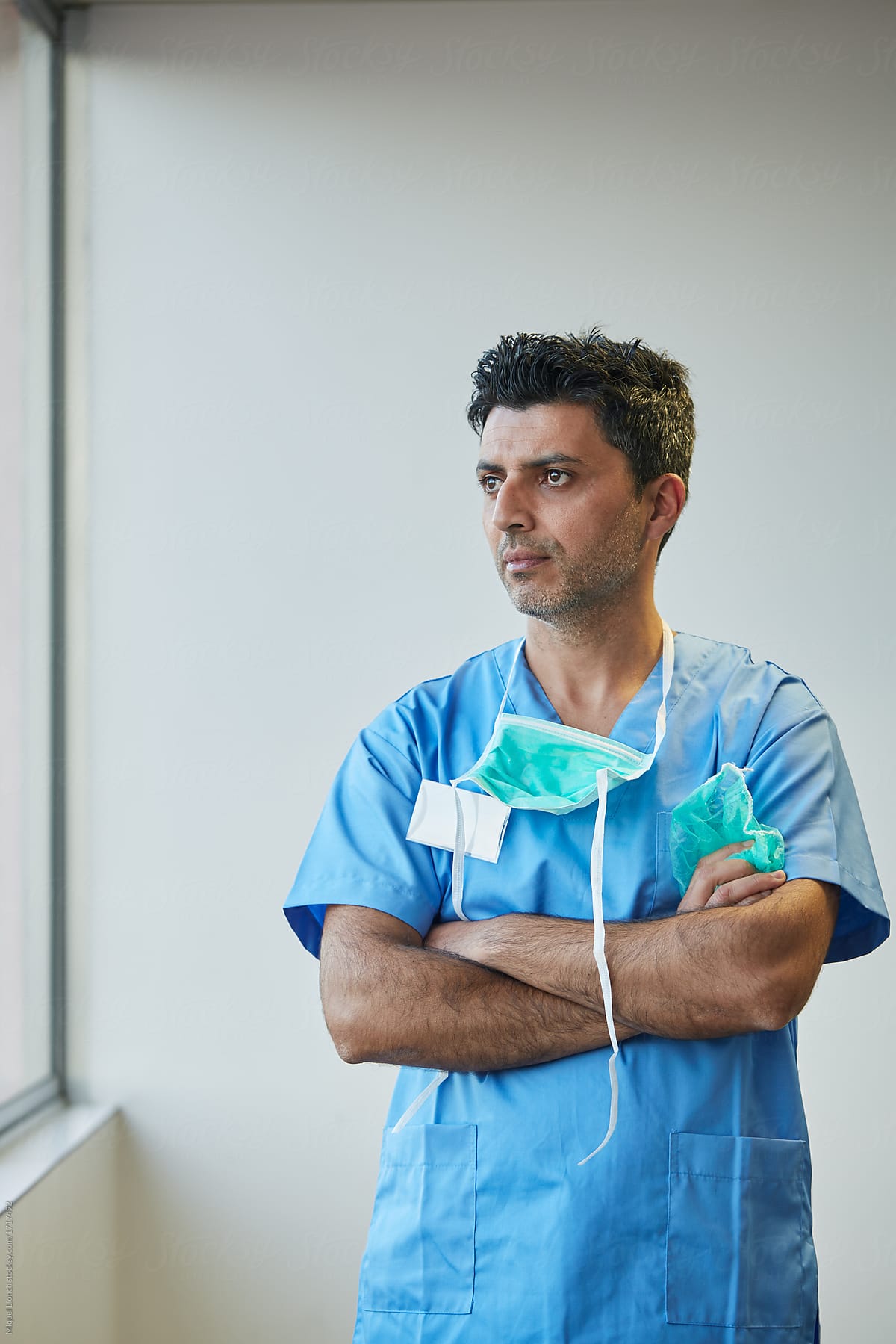 Portrait of middle eastern doctor with operating clothes in a hospital corridor