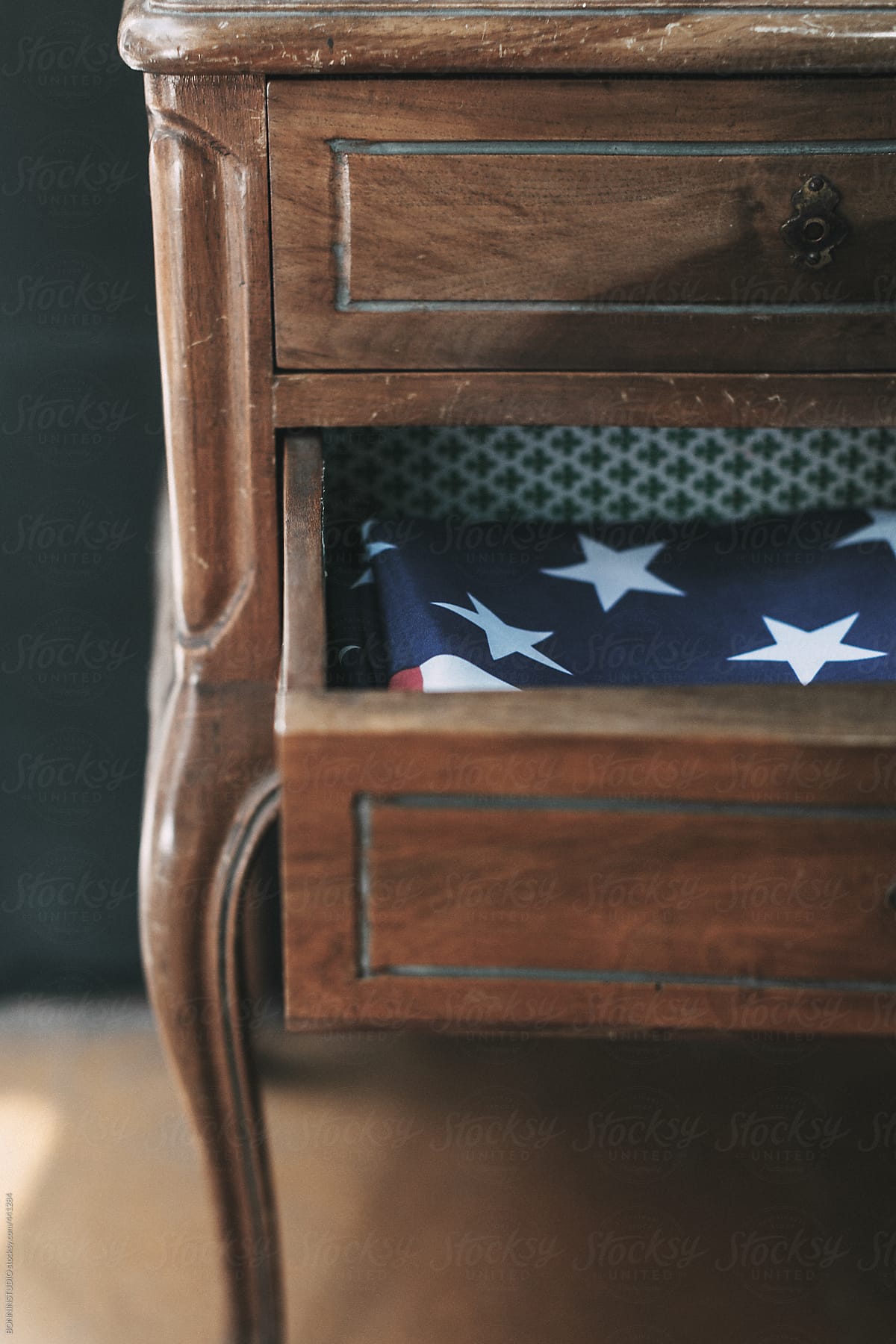American flag inside drawer on wood side table.
