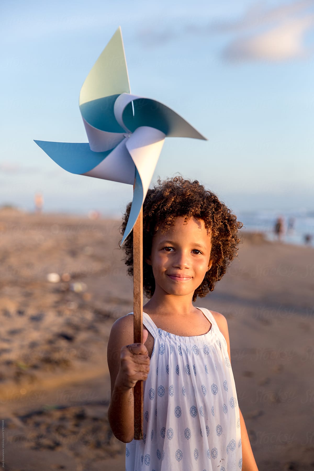 Girl holding pinwheel toy at the beach