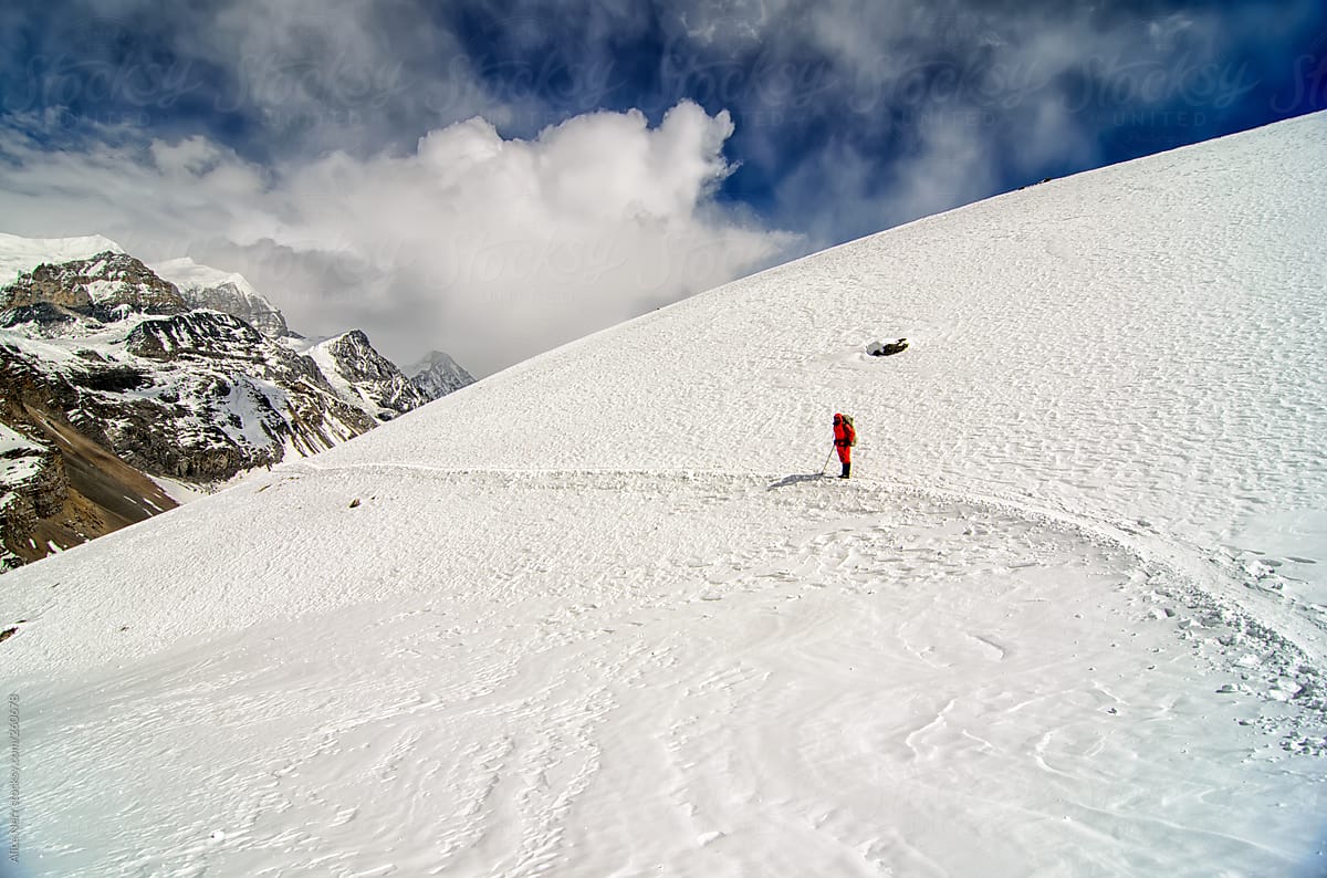 A Hiker on a Snowy Trekking Path in Mountains