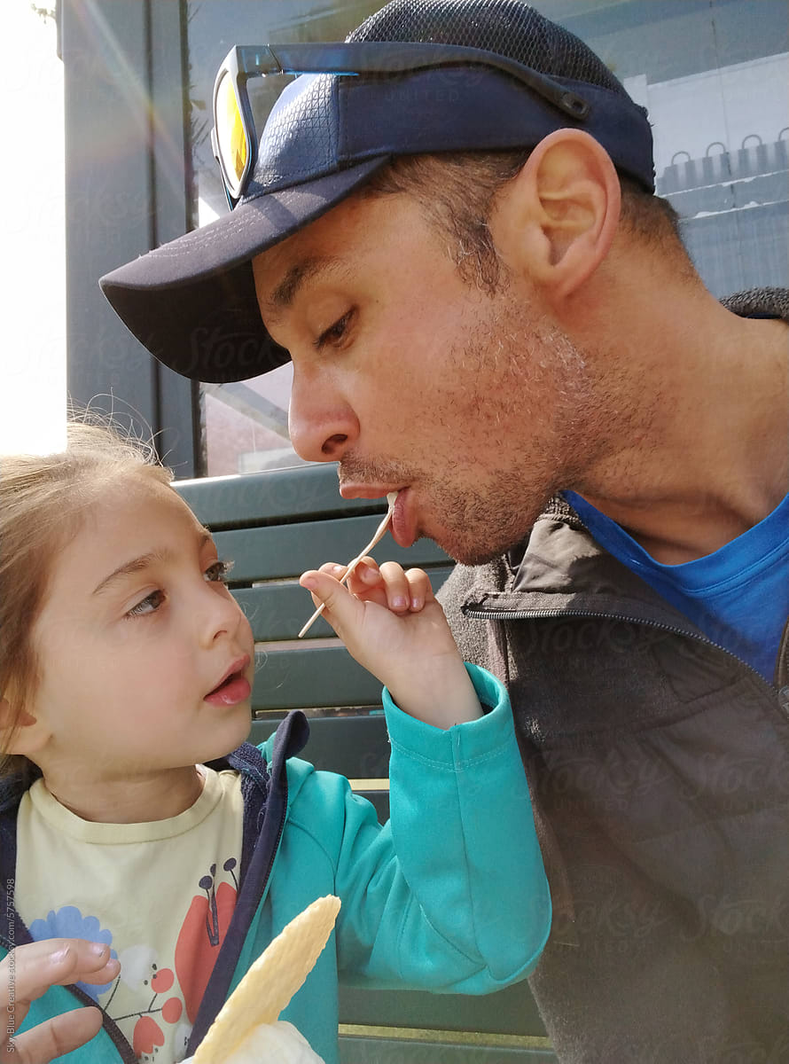 Girl generously shares some of her ice cream with her dad