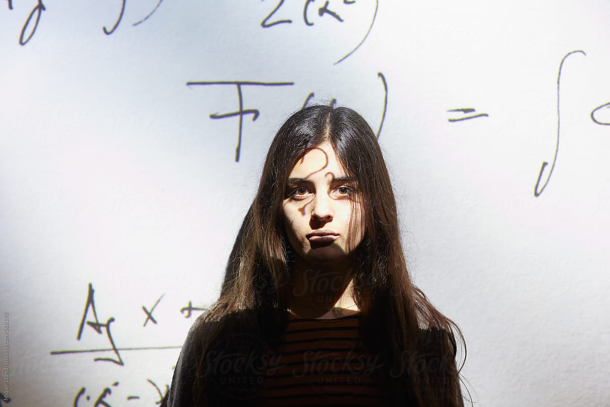 Female student in front of an interactive digital screen with formulas