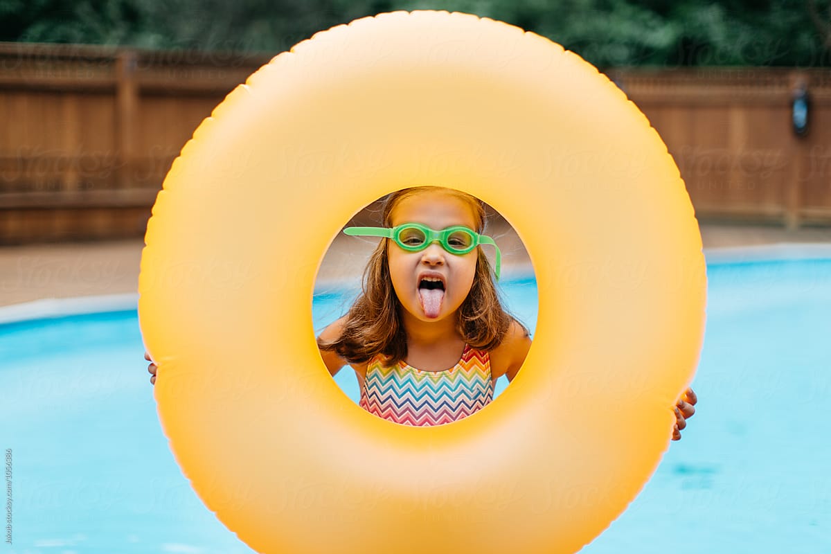 Cute Young Girl Playing With Her Inner Tube By A Pool By Stocksy 