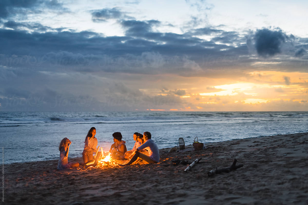friends sitting by the fire on the beach