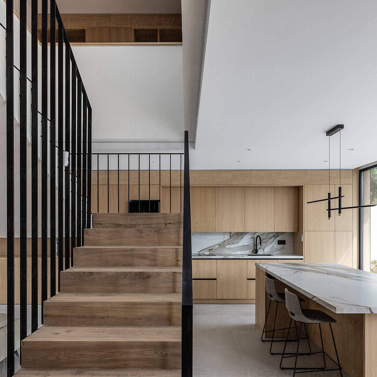 Minimalist kitchen with stairs leading to the upper floor of the home