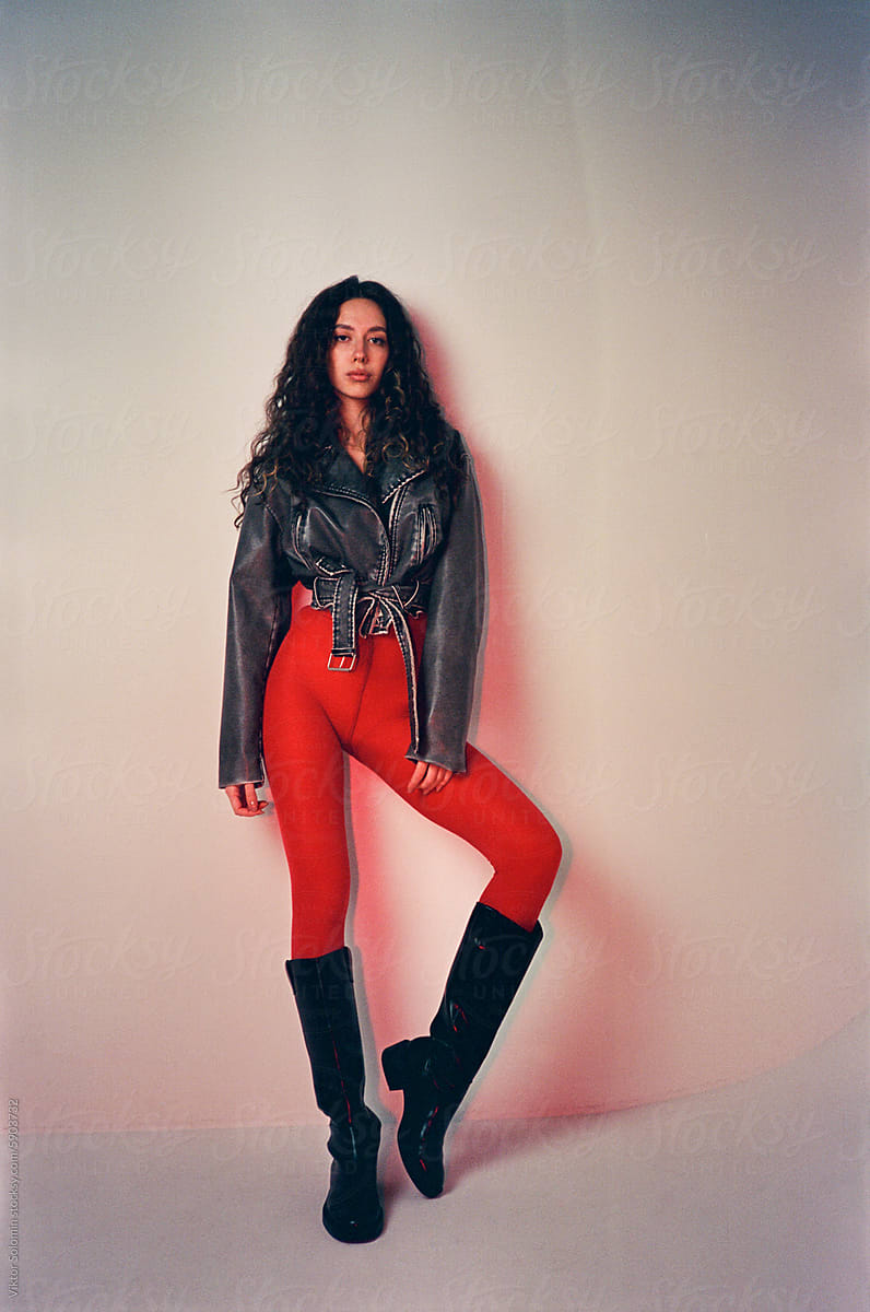 Stylish woman in leather boots, red tights and jacket