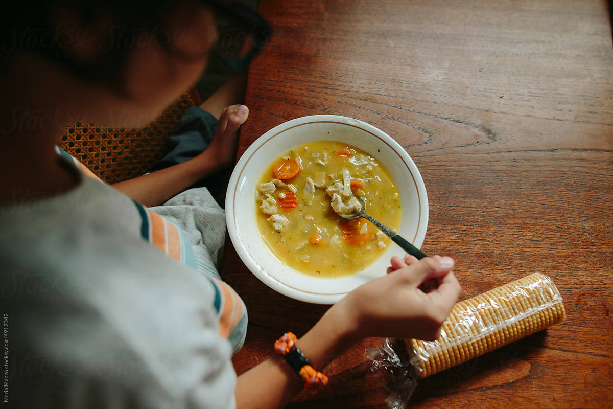 Tween boy eats chicken noodle soup